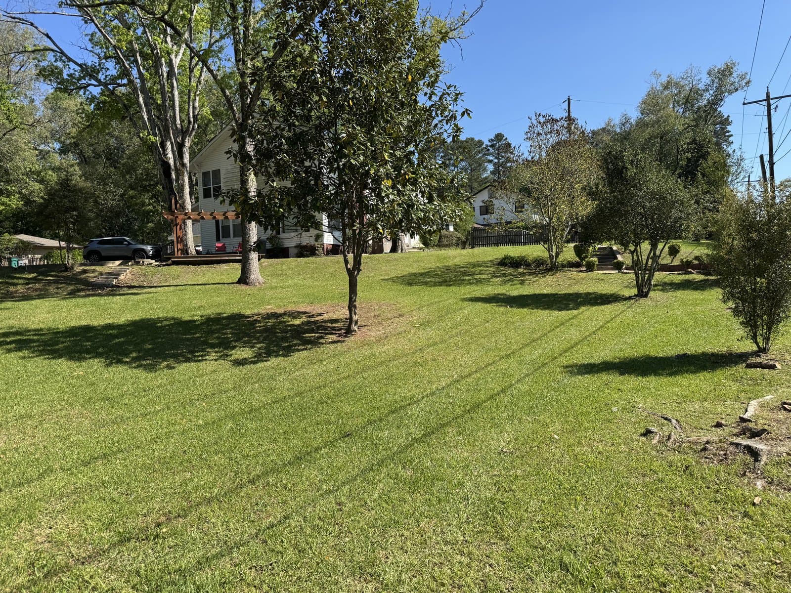 White farmhouse behind a sweeping lawn with fresh mow stripes